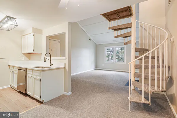 a kitchen with white cabinets and sink
