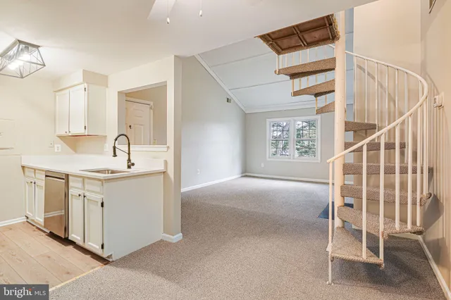 a kitchen with white cabinets and sink