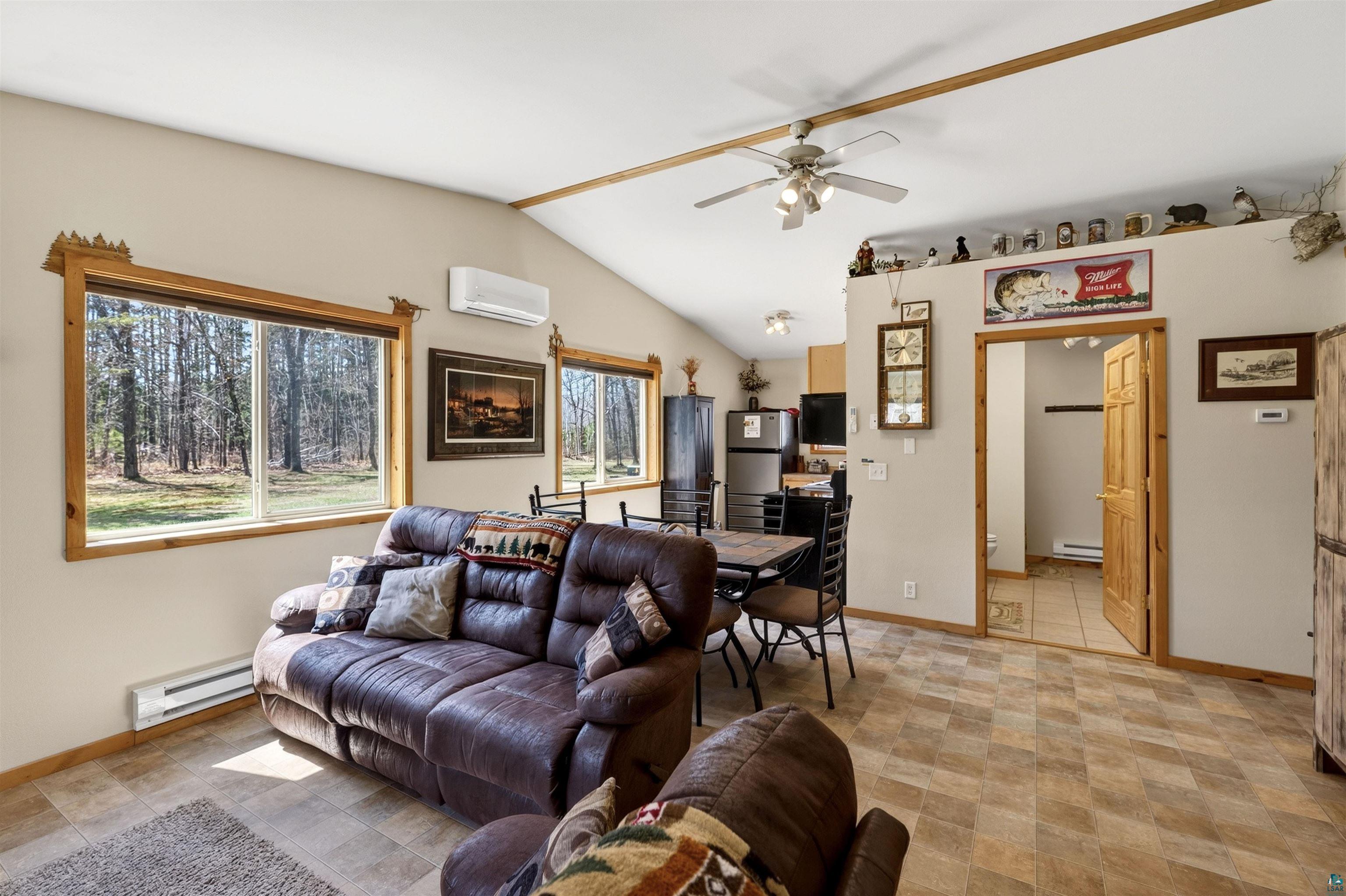12235 East Crooked Lake Road Gordon, WI 54838 - Photo 24 of 48 Open-concept living space featuring vaulted ceilings, wood-finish window trim, and large windows