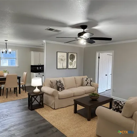 a living room with furniture and wooden floor