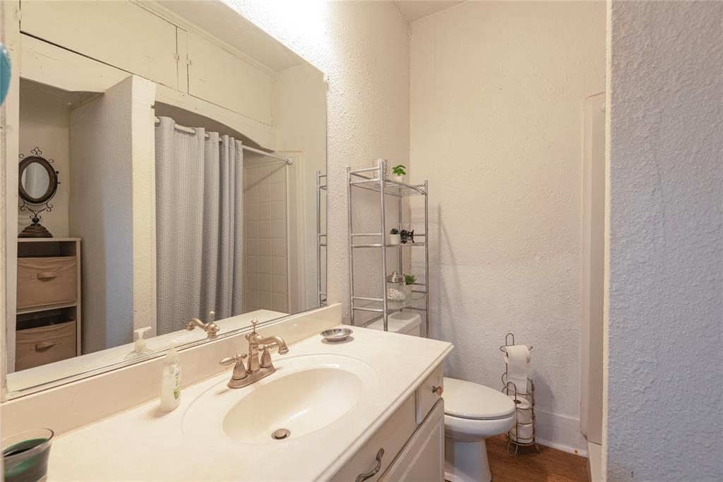 1909 Sycamore Street Commerce, TX 75428 - Photo 11 of 26 a bathroom with a sink toilet and shower