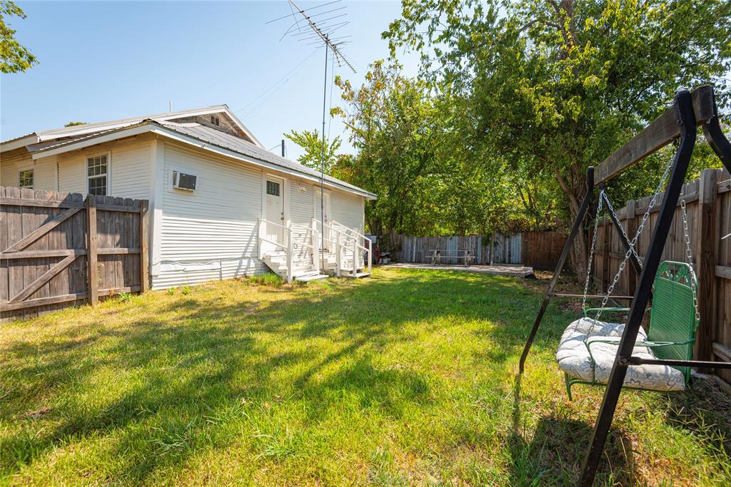 1909 Sycamore Street Commerce, TX 75428 - Photo 19 of 26 a backyard of a house with table and chairs