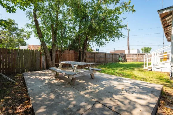 a view of backyard with table and chairs and wooden fence