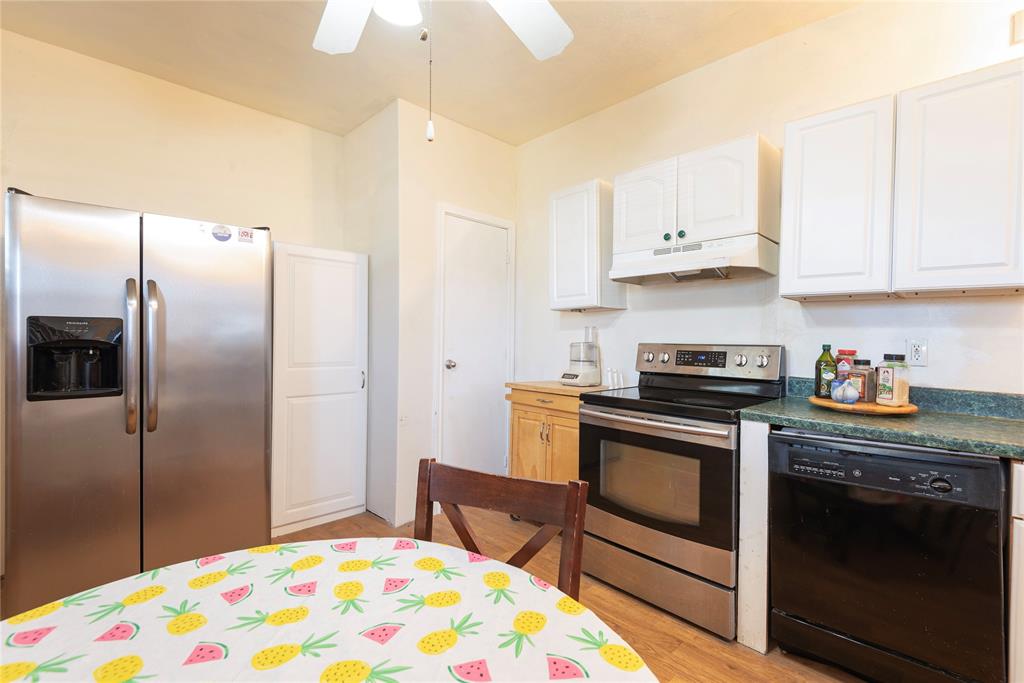 1909 Sycamore Street Commerce, TX 75428 - Photo 8 of 26 a kitchen with stainless steel appliances granite countertop a stove a refrigerator and a sink with cabinets