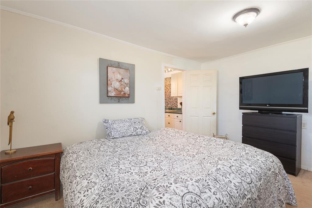 1909 Sycamore Street Commerce, TX 75428 - Photo 10 of 26 a bedroom with a bed and a flat screen tv