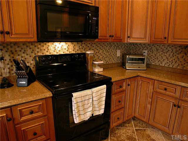 21 Kissimee Court Durham, NC 27713 - Photo 24 of 25 a kitchen with stainless steel appliances granite countertop a stove a microwave and oven