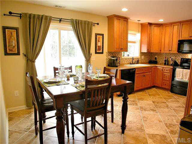 21 Kissimee Court Durham, NC 27713 - Photo 3 of 25 a dining room with a table chairs and a kitchen view