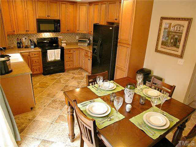21 Kissimee Court Durham, NC 27713 - Photo 9 of 25 a kitchen with stainless steel appliances wooden floor dining table and chairs