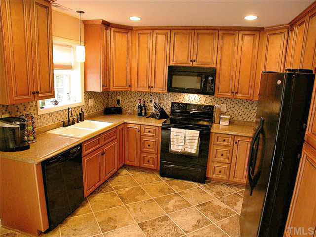 21 Kissimee Court Durham, NC 27713 - Photo 10 of 25 a kitchen with stainless steel appliances granite countertop a stove sink and cabinets