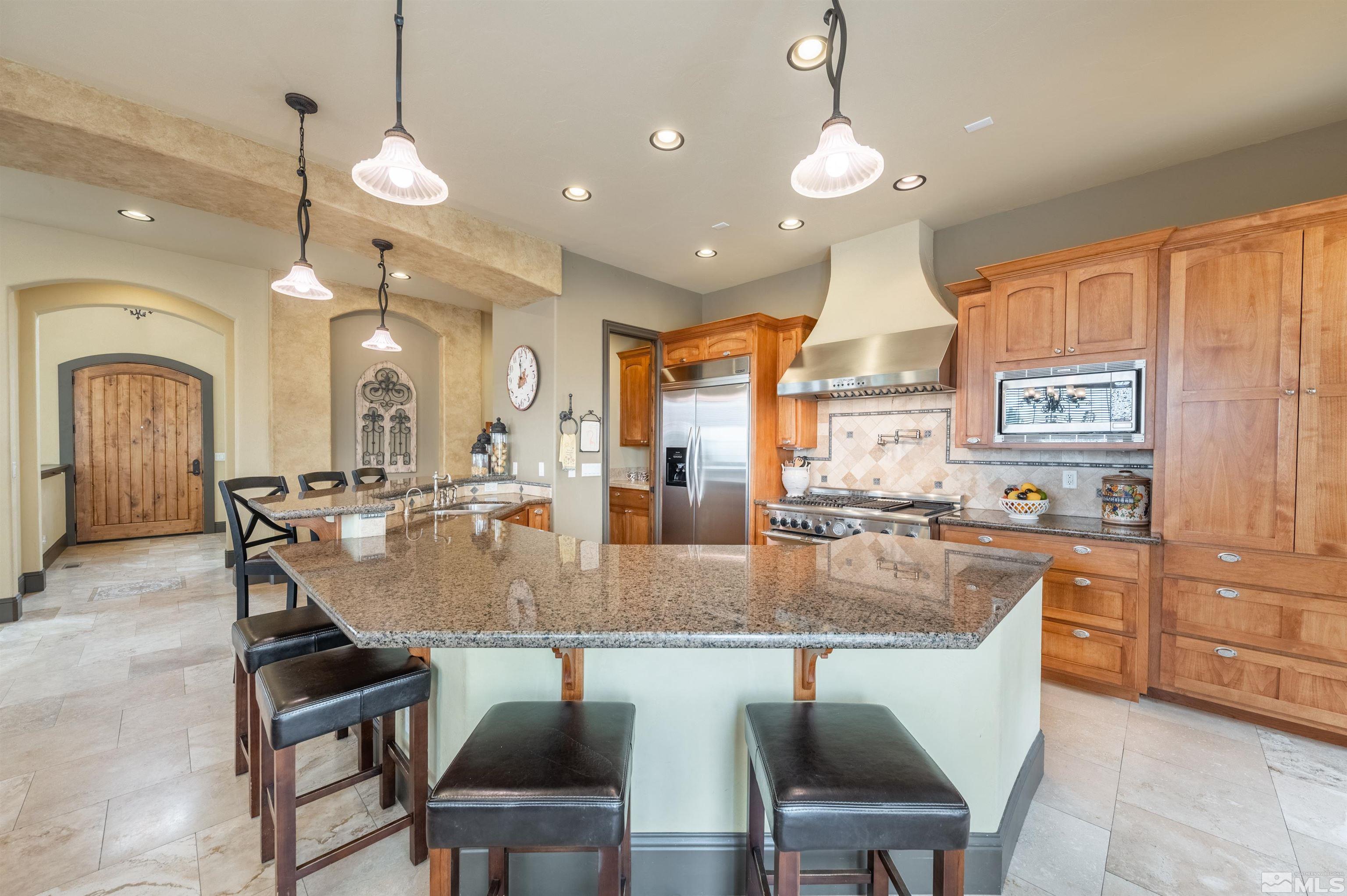 4271 Dant Boulevard Reno, NV 89509 - Photo 4 of 24 a kitchen with a dining table chairs stainless steel appliances and cabinets