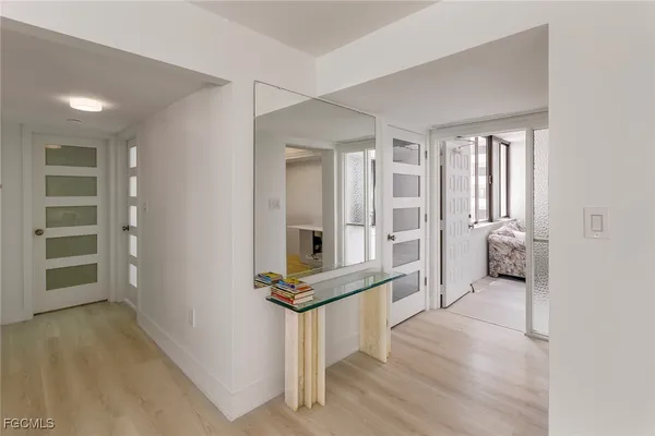 a view of a hallway with wooden floor and entryway