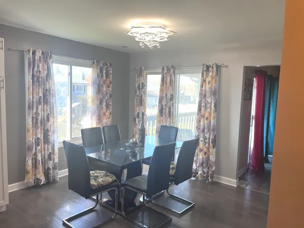 a living room with stainless steel appliances furniture a window and kitchen view
