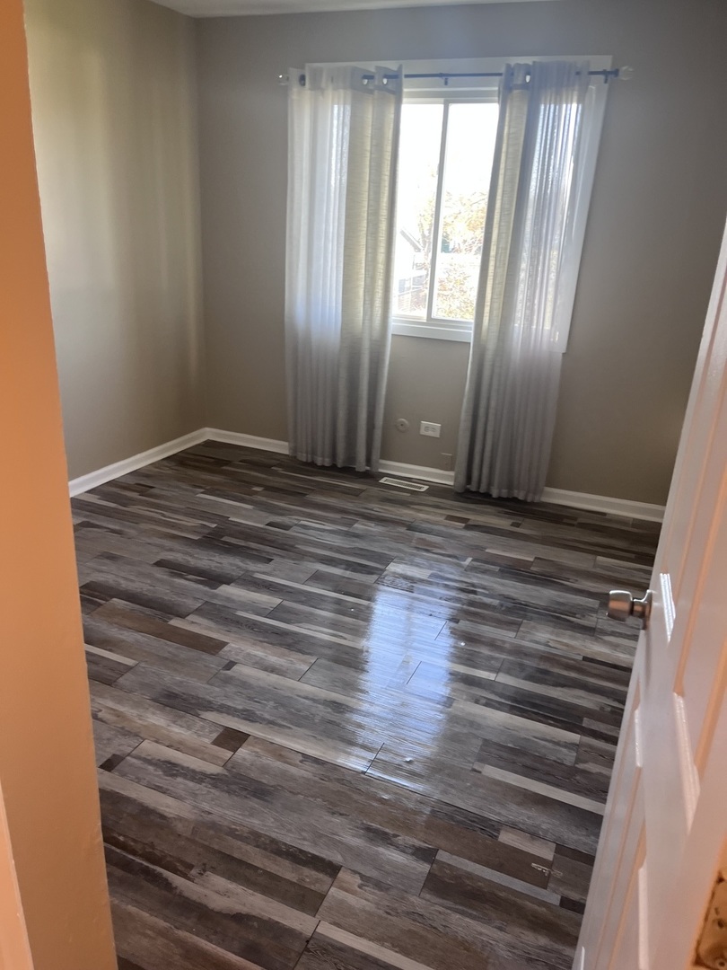 56 Timberlane Road Matteson, IL 60443 - Photo 18 of 40 a view of an empty room with wooden floor and a window