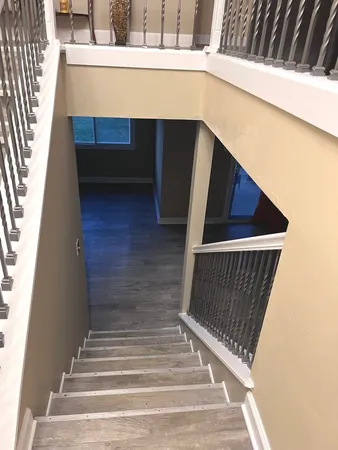 a view of an empty room with wooden floor fireplace and a window