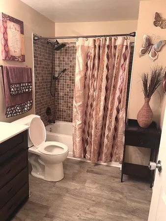 a bathroom with a toilet and a shower curtain