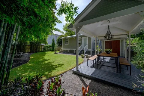a view of a chair and table in backyard of the house