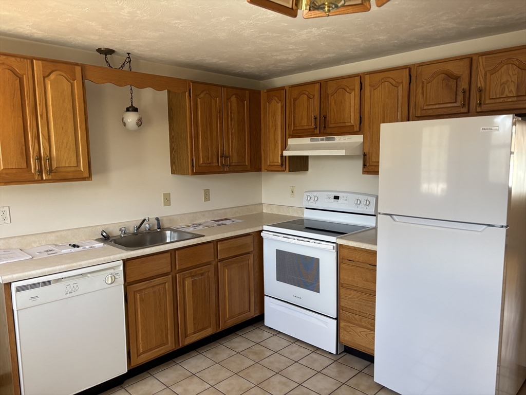 94 Monroe Street, Unit 2 Douglas, MA 01516 - Photo 6 of 10 a kitchen with a sink a stove a refrigerator and cabinets