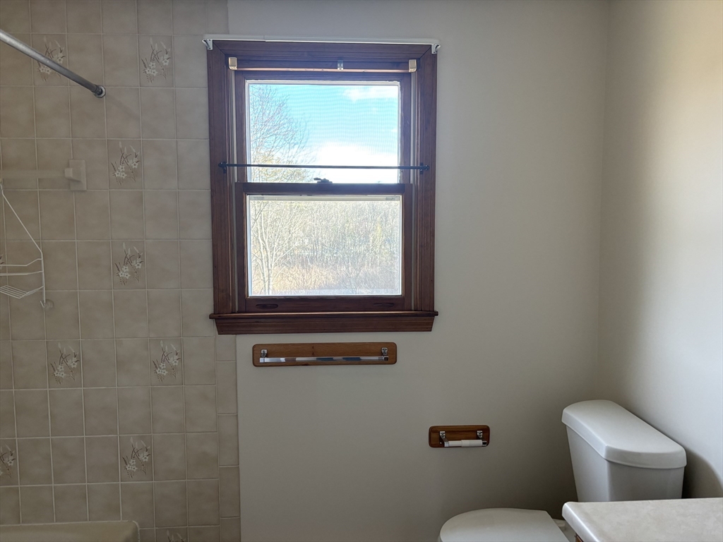 94 Monroe Street, Unit 2 Douglas, MA 01516 - Photo 7 of 10 a white toilet sitting next to a window