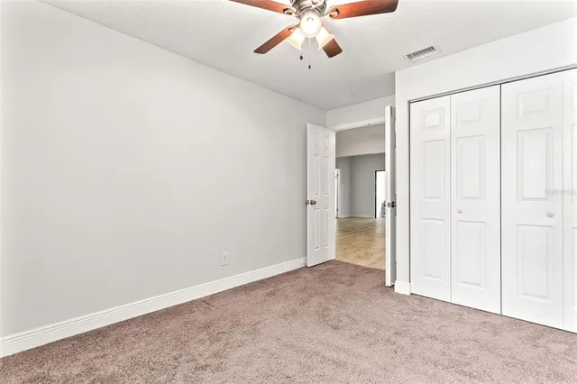an empty room with a ceiling fan and a window