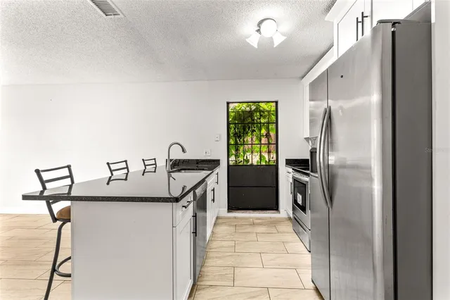 a kitchen with stainless steel appliances granite countertop a refrigerator a sink and a stove