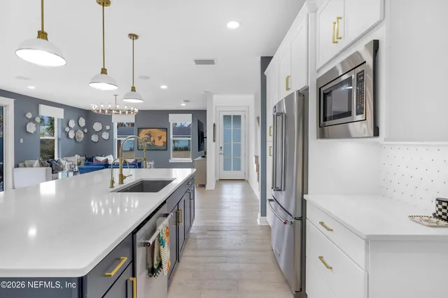 a kitchen with stainless steel appliances granite countertop a sink a stove and a refrigerator