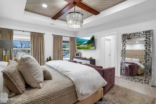 a spacious bedroom with a bed and a chandelier