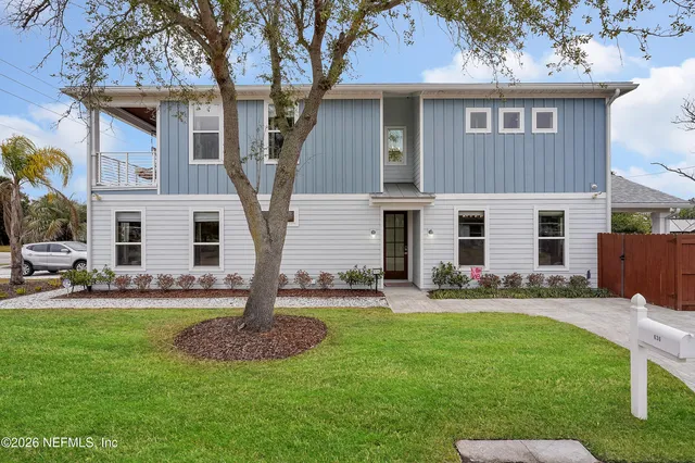 a front view of a house with a yard and chairs