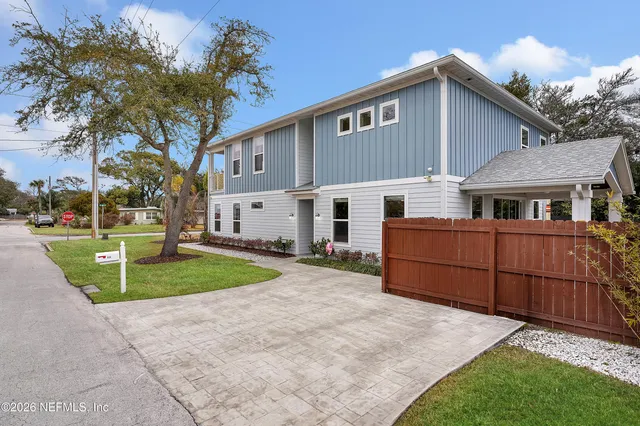 a front view of a house with a yard and trees