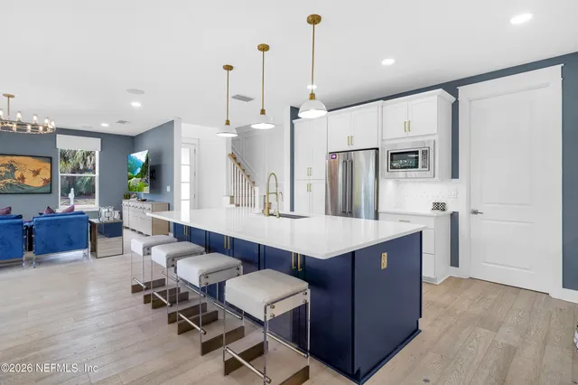 a kitchen with kitchen island a wooden floor and white appliances