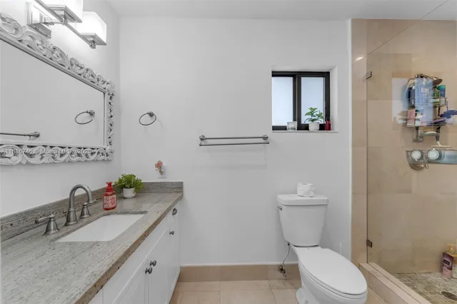a bathroom with a granite countertop sink mirror vanity and toilet