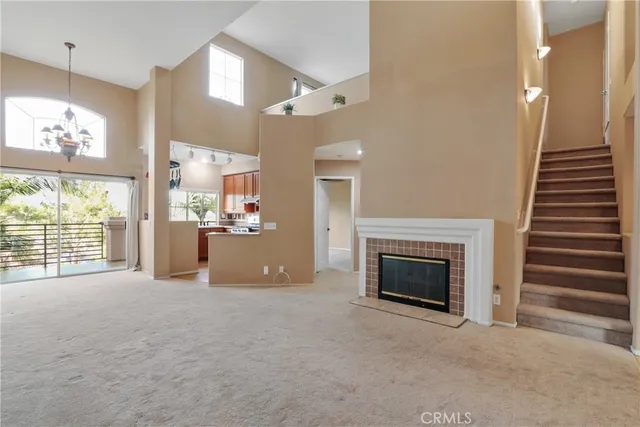 a view of an empty room with a fireplace and a window