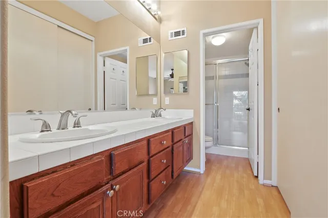 a spacious bathroom with a double vanity sink mirror and shower
