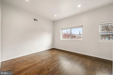 a view of an empty room with wooden floor