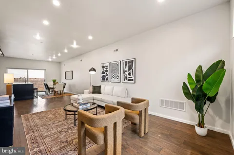 a living room with furniture a potted plant and a table