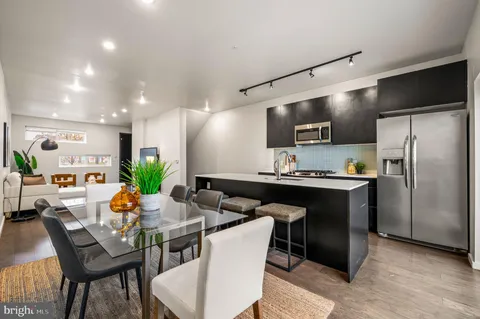 a living room with stainless steel appliances kitchen island granite countertop a dining table and chairs