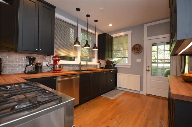 a kitchen with stainless steel appliances granite countertop a stove a sink and a refrigerator
