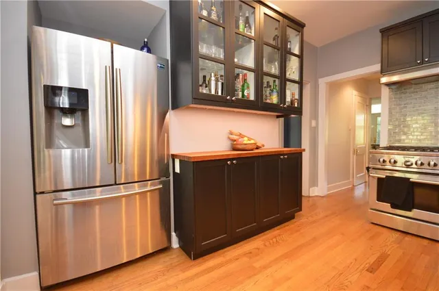 a kitchen with stainless steel appliances granite countertop a refrigerator and a stove