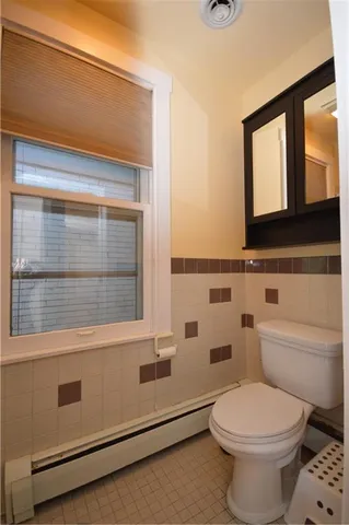 a bathroom with a toilet a sink and a mirror