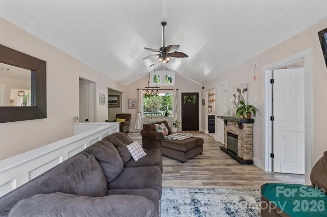 a living room with furniture a fireplace and a chandelier