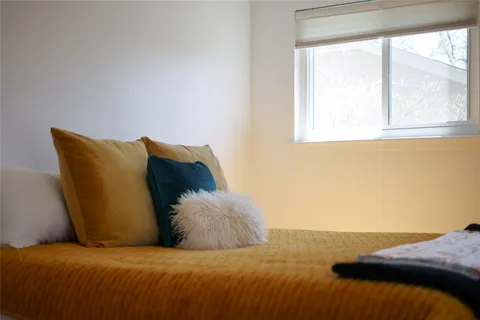 a bed sitting in a bedroom next to a window