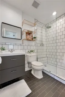 a bathroom with a toilet sink vanity and mirror