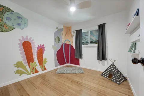 a view of a bedroom with wooden floor and bed