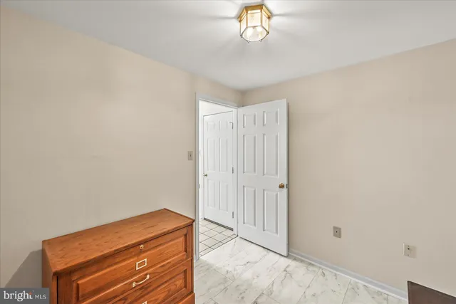 a room with a chandelier fan and wooden floor