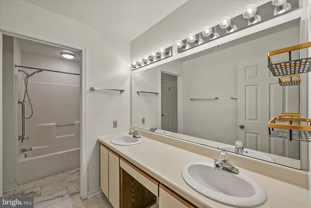 a bathroom with a sink double vanity granite tub and shower