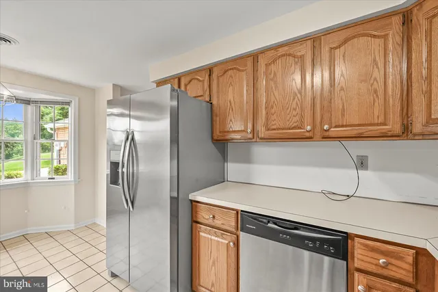a kitchen with stainless steel appliances granite countertop a refrigerator a sink and cabinets