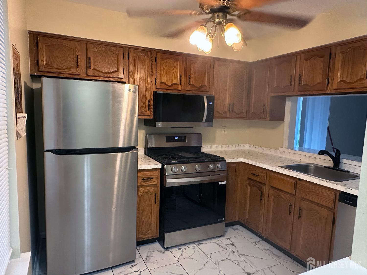 603 Woodbridge Commons Way Iselin, NJ 08830 - Photo 8 of 14 a kitchen with metallic refrigerator and microwave