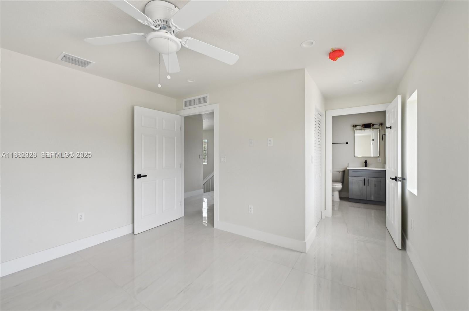 10344 Northwest 29th Avenue, Unit 10344 Miami, FL 33147 - Photo 11 of 12 a view of a bedroom with a furniture and ceiling fan