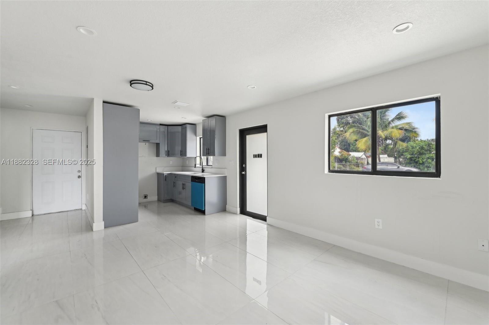 10344 Northwest 29th Avenue, Unit 10344 Miami, FL 33147 - Photo 3 of 12 a view of a kitchen with wooden cabinet and a refrigerator