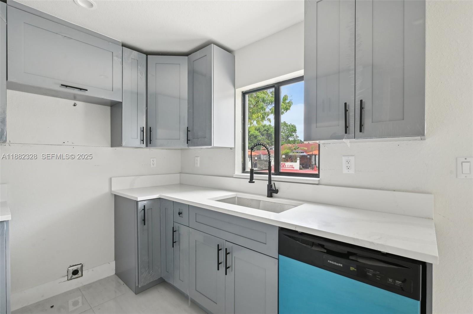 10344 Northwest 29th Avenue, Unit 10344 Miami, FL 33147 - Photo 5 of 12 a kitchen with a sink cabinets and window