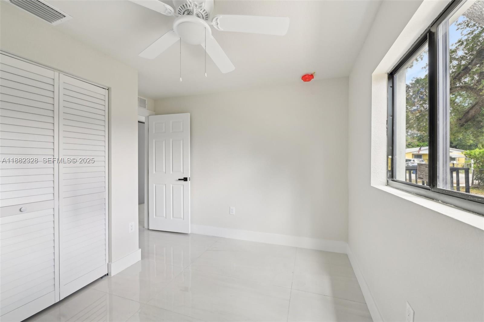 10344 Northwest 29th Avenue, Unit 10344 Miami, FL 33147 - Photo 7 of 12 an empty room with windows and cabinet